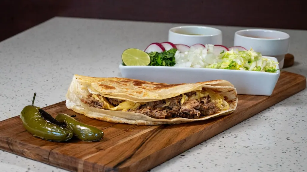 Taco-Madrazo: quesabirria en tortilla de harina con queso derretido, chiles toreados y verdura