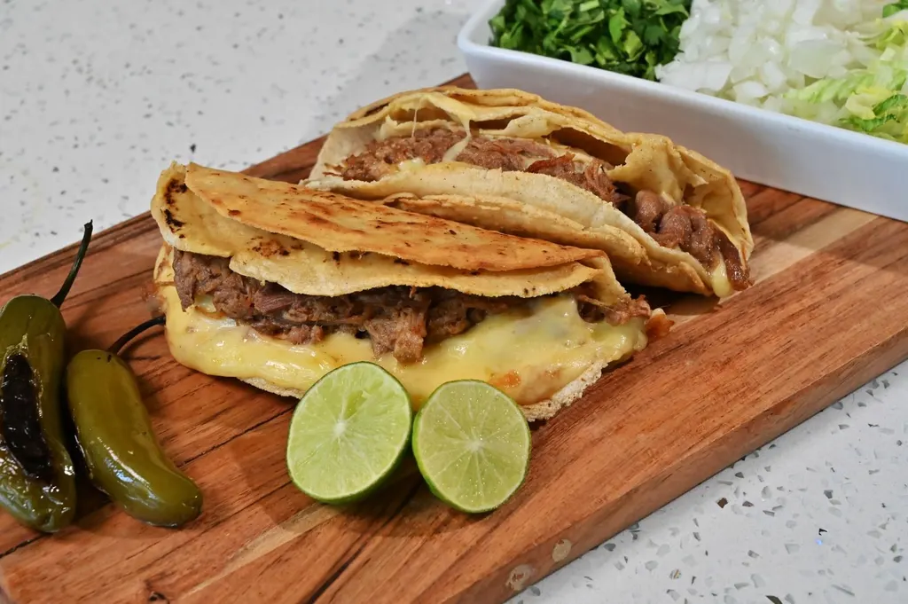 Tacos especiales con chiles toreados y limones sobre tabla