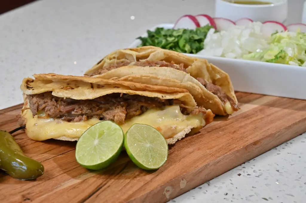 Tacos especiales con queso derretido y limones